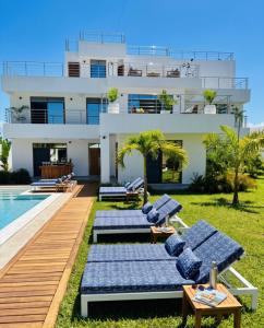 a villa with a swimming pool and two lounge chairs at Casa Samara in Diani Beach