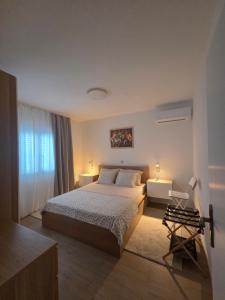 a bedroom with a large bed and a window at Apartmani ANCORA, Crkvice in Kuna Pelješka
