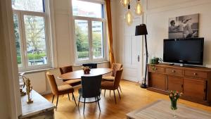 a living room with a table and a tv at AGENCE MOMENT'APART Legend in Mouvaux