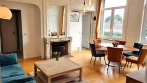 a living room with a couch and a table at AGENCE MOMENT'APART Legend in Mouvaux