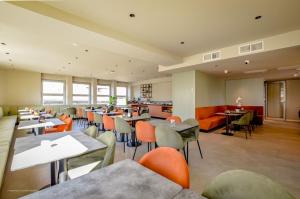 a restaurant with tables and chairs and a cafeteria at CP Hotels - Central in Milan