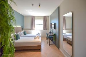 a hotel room with a bed and a mirror at CP Hotels - Central in Milan +90 photos