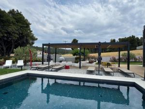 a swimming pool with chairs and a gazebo at Sani e belli, Villas with private pool in Sani Beach +101 photos