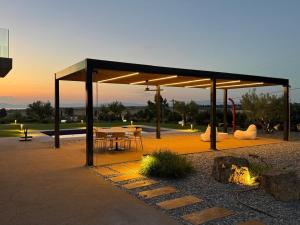 a pavilion with a table and chairs in a park at Sani e belli, Villas with private pool in Sani Beach
