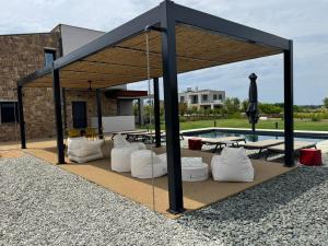a pavilion with white pillows and a pool at Sani e belli, Villas with private pool in Sani Beach