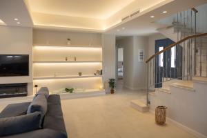 a living room with a couch and a tv at Elysium Exclusive Villas in Áyioi Saránda