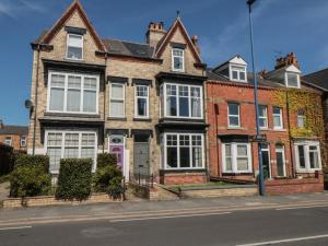 a brick house with a pink door on a street at Ruby's Retreat in Filey
