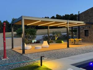 a pavilion with chairs and tables and a pool at Sani e belli, Villas with private pool in Sani Beach