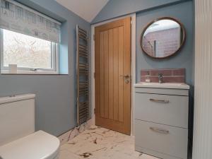 a bathroom with a toilet and a sink and a mirror at Ruby's Retreat in Filey +36 photos