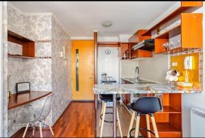 a kitchen with a counter and stools in a room at Lupe&Lulu aparments in Santiago