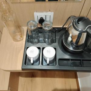 a stove top with a tea pot and glasses on it at Hotel Sun City in Kalol