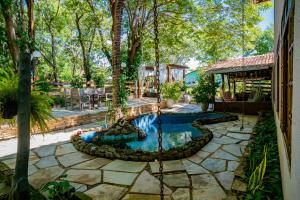 a swimming pool in a yard with a swing at Pousada Aconchego in Pirenópolis