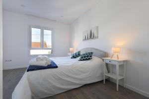 a white bedroom with a bed and a nightstand and a window at Villa Piscina Privada 3 Quartos 8 Hóspedes in Fernao Ferro +51 photos