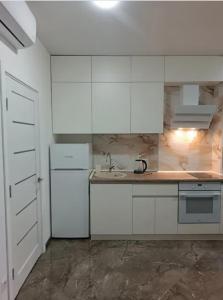 a white kitchen with a sink and a refrigerator at ЖК Акрополь, Парк Перемоги, Аркадія in Odesa