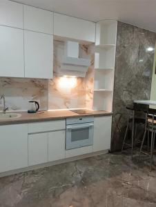 a kitchen with white cabinets and a sink and a table at ЖК Акрополь, Парк Перемоги, Аркадія in Odesa +14 photos