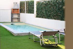 a swimming pool with two lawn chairs next to it at Villa Piscina Privada 3 Quartos 8 Hóspedes in Fernao Ferro