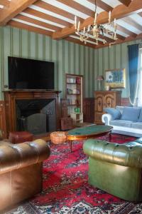 a living room with a couch and a table and a fireplace at Clos de Joco - Gîte de groupe in Pas-de-Jeu