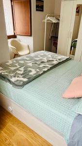 a bed with a green and white comforter on it at Acogedor apartamento parque Aizkorri-Aratz a 45 min San Sebastian in Araya