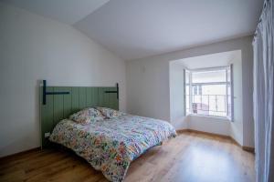 a bedroom with a bed and a window at Le Gîte du Moulin in Saint-Maigrin