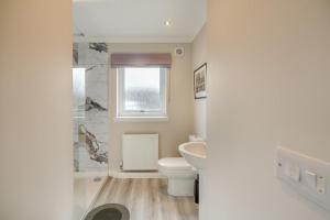 a white bathroom with a toilet and a sink at 2 Bed in Ochiltree oc-w37516 in Ochiltree +16 photos