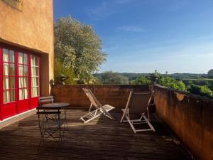 two chairs and a table on a wooden deck at Logis Hôtel Le Boudoir in Belvès