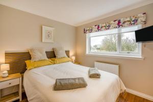 a bedroom with a large white bed with a window at 2 Bed in Ochiltree oc-w37517 in Ochiltree