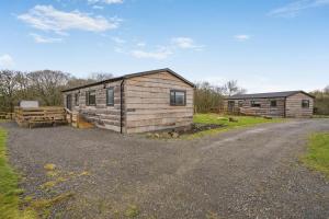 a small wooden cabin with a fence next to a road at 2 Bed in Ochiltree oc-w37517 in Ochiltree