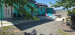 a blue house with a table and a chair at Olive Grove Retreat Podgorica in Vranj