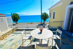 a table and chairs on a balcony with a view of the ocean at Thalassa Seaside Apartments in Sikéa