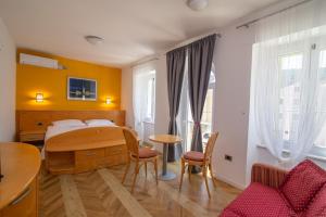 a bedroom with a bed and a table and chairs at Bed&Breakfast Saturn in Veli Lošinj