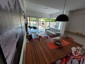 a dining room with a wooden table and chairs at Vila Sol Serrambi in Porto De Galinhas