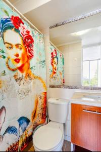 a bathroom with a shower curtain and a toilet at Lupe&Lulu aparments in Santiago