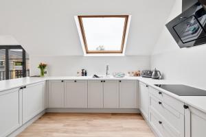a kitchen with white cabinets and a window at Corn Flour Lodge - Pitkerro Mill in Dundee +20 photos