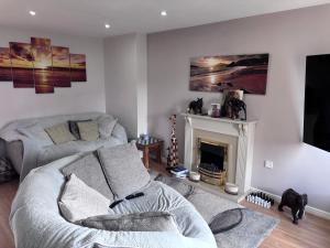 a living room with a couch and a fireplace at Private Hydro Spa Pool, Dbl Bedrm & Bathrm - Other areas part private shared lived-in home in Bickershaw