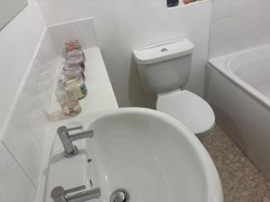 a white bathroom with a toilet and a sink at Private Hydro Spa Pool, Dbl Bedrm & Bathrm - Other areas part private shared lived-in home in Bickershaw +15 photos