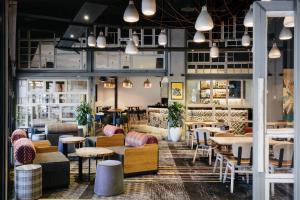 a restaurant with tables and chairs in a room at voco Gold Coast by IHG in Gold Coast