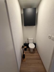 a bathroom with a toilet and a television on the wall at Numéro 6 in Toulouse