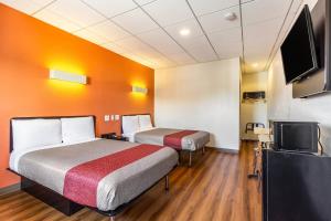 a room with two beds and a flat screen tv at Hotel Elizabeth Near Newark Liberty International Airport New Jersey in Elizabeth