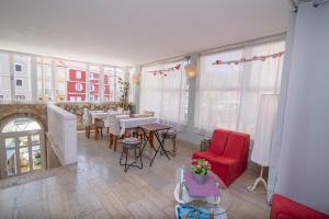 a living room with a red chair and a table at Bed&Breakfast Saturn in Veli Lošinj