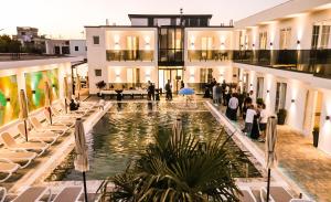 Eine Gruppe von Menschen steht um einen Pool in einem Gebäude herum. in der Unterkunft Hotel Kosova in Velipojë
