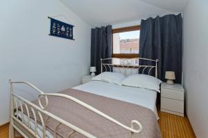 a small bedroom with a bed and a window at Apartment Plaza in Hvar