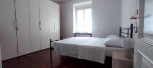 a white bedroom with a bed and a window at Alloggio Maia 2 in Biella