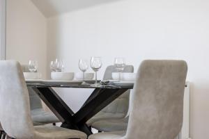 a dining room table with chairs and wine glasses at Corn Flour Lodge - Pitkerro Mill in Dundee