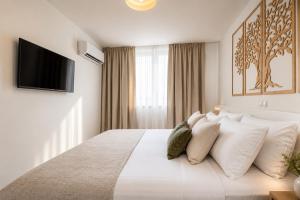 a white bedroom with a large bed with white pillows at Premium Residence Virotel in Vir