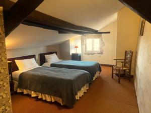 a bedroom with two beds and a window at Logis Hôtel Le Boudoir in Belvès