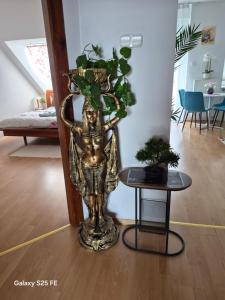 a statue of a man holding a plant in a room at Zafir Luxory in Kaposvár