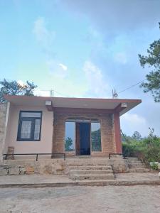 a small house with a large door in the middle at Nashlem Homestay in Mawphlang