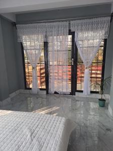 a bedroom with a bed and a large window at Nashlem Homestay in Mawphlang