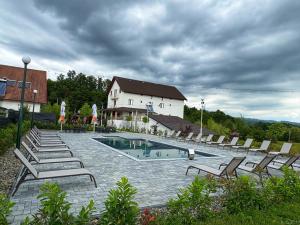 a swimming pool with lounge chairs and a building at Rem Garden in Novaci-Străini