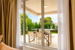 a room with a glass window with a table and chairs at Premium Residence Virotel in Vir